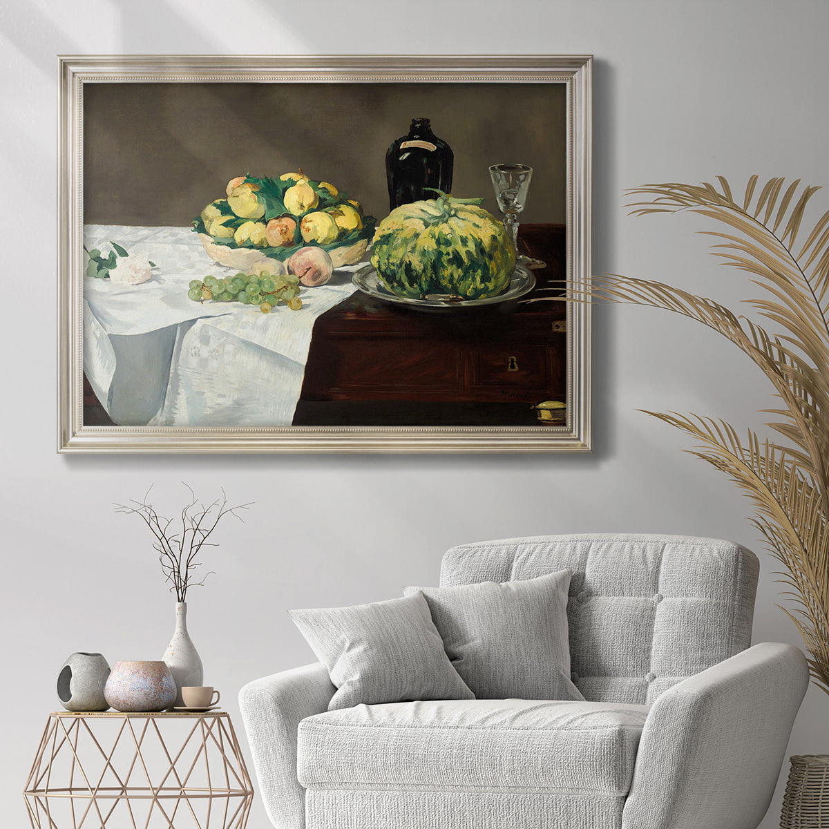 Impressionist still life with fruit by Édouard Manet in an ornate champagne frame displayed in a bright interior setting.