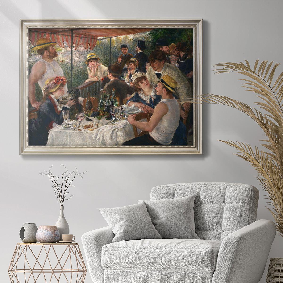 Impressionist social luncheon scene by Pierre-Auguste Renoir in an ornate champagne frame displayed in a bright interior setting.