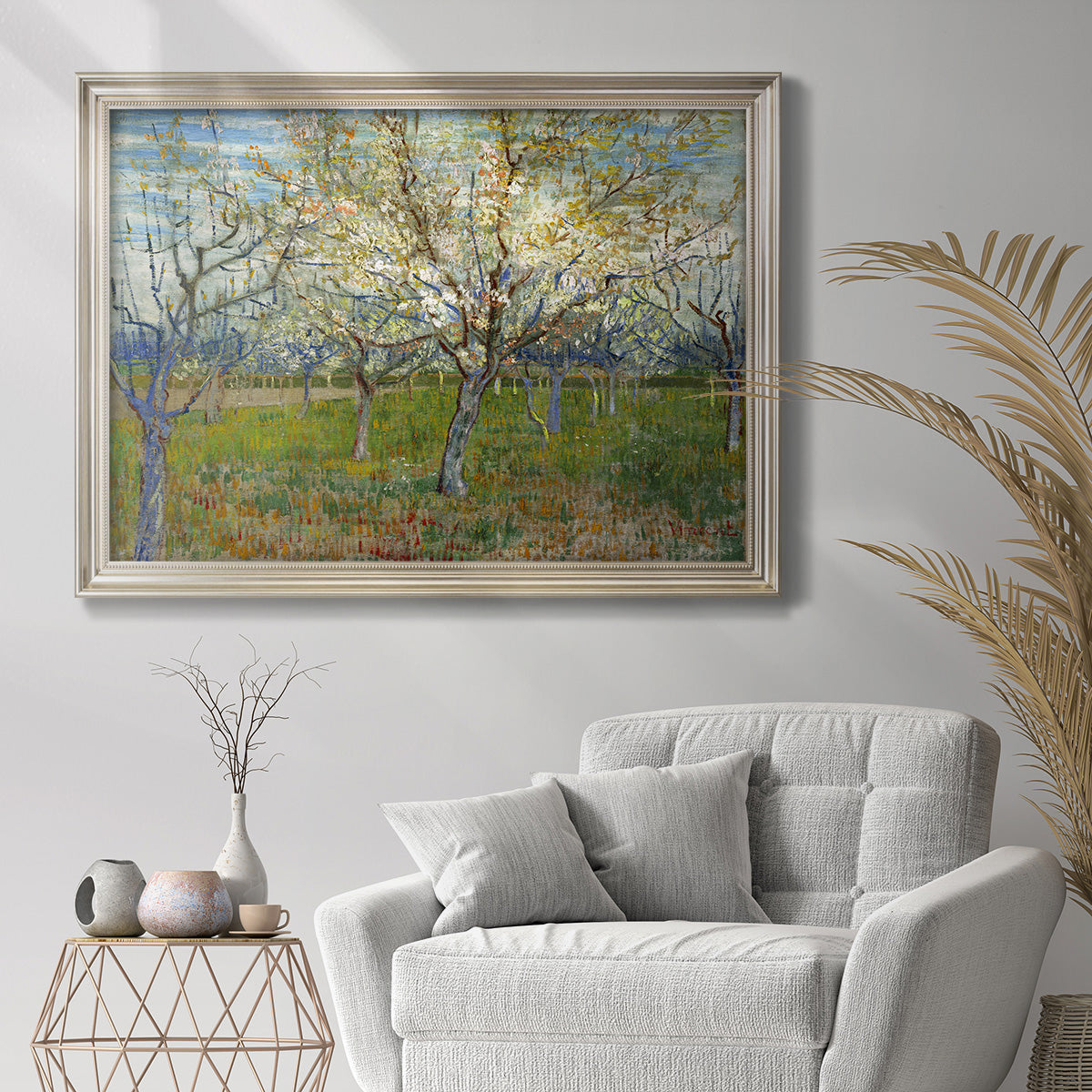 Impressionist apricot orchard in bloom by Vincent van Gogh in an ornate champagne frame displayed in a bright interior setting.