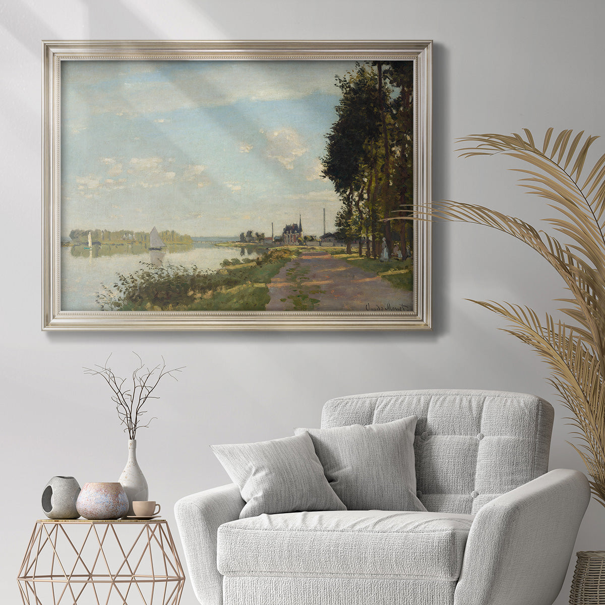Impressionist river scene with red boats by Claude Monet in an ornate champagne frame displayed in a bright interior setting.