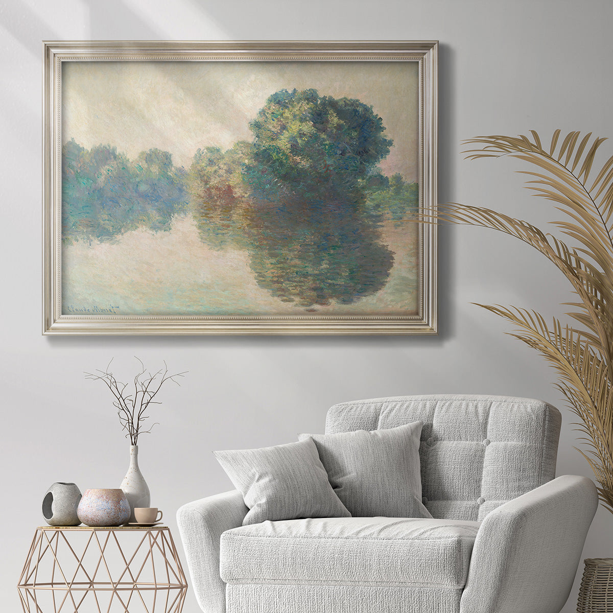 Impressionist river landscape at Giverny by Claude Monet in an ornate champagne frame displayed in a bright interior setting.
