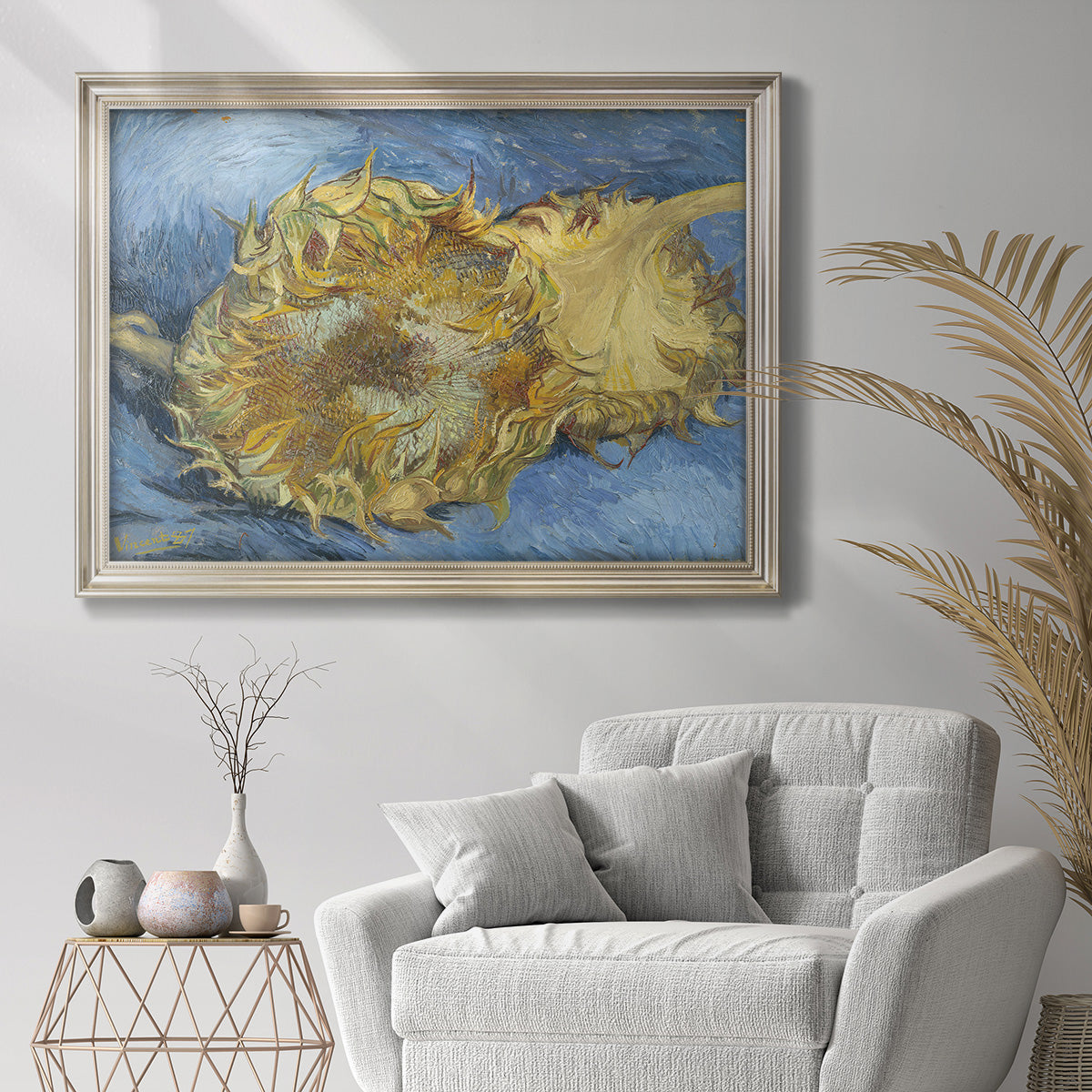 Impressionist sunflower still life by Vincent van Gogh in an ornate champagne frame displayed in a bright interior setting.