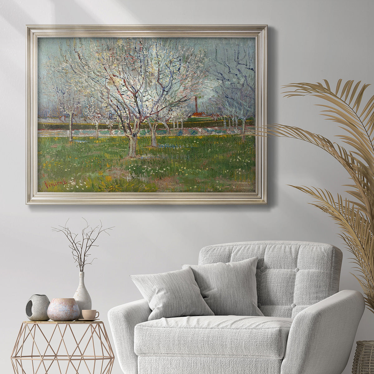 Impressionist blooming orchard scene by Vincent van Gogh in an ornate champagne frame displayed in a bright interior setting.