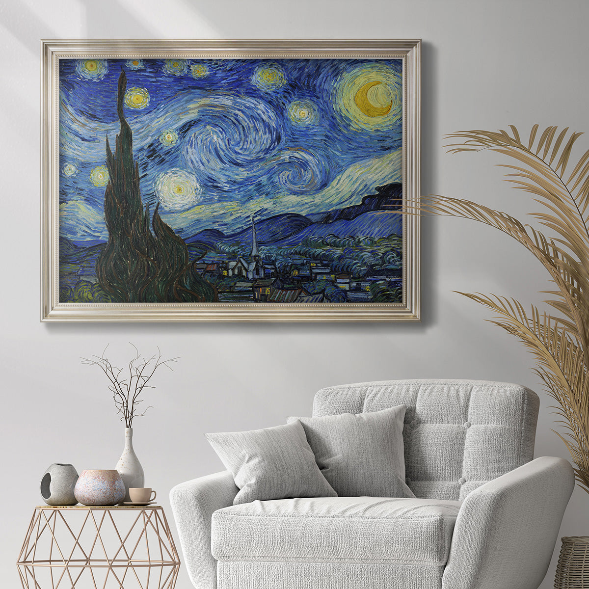 Iconic night sky landscape painting by Vincent van Gogh in an ornate champagne frame displayed in a bright interior setting.