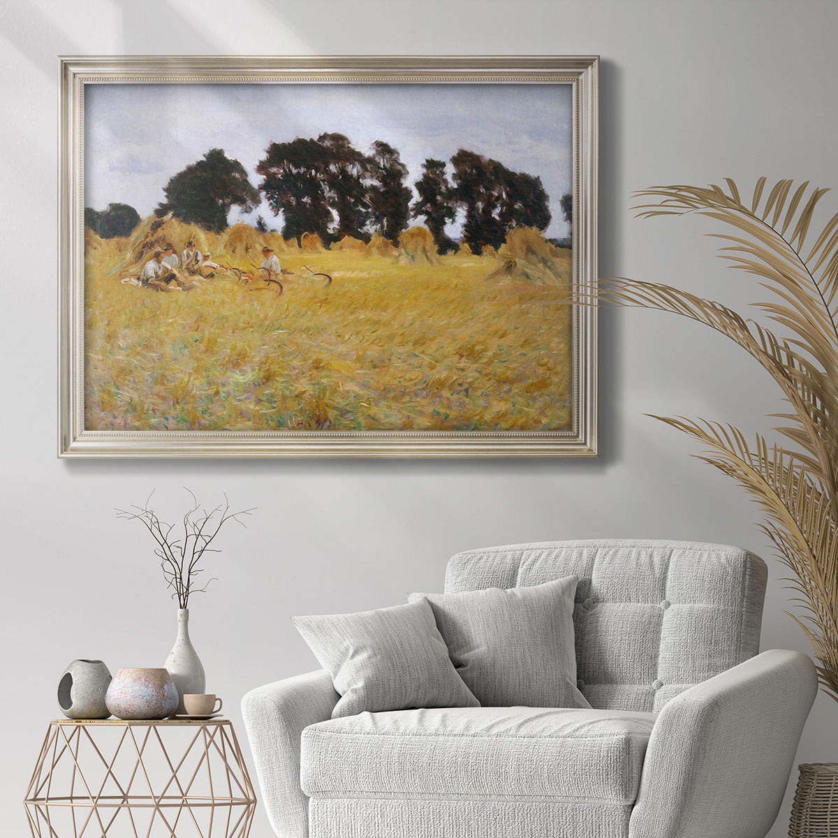 Impressionist rural harvest scene by John Singer Sargent in an ornate champagne frame displayed in a bright interior setting.