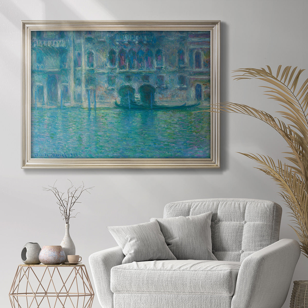 Impressionist Venetian palace waterfront scene by Claude Monet in an ornate champagne frame displayed in a bright interior setting.