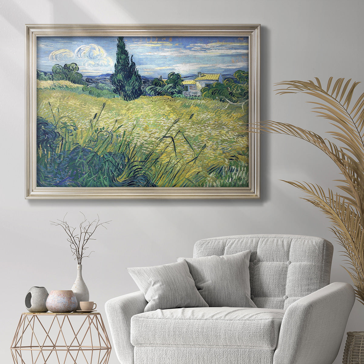 Impressionist rural wheat field landscape by Vincent van Gogh in an ornate champagne frame displayed in a bright interior setting.