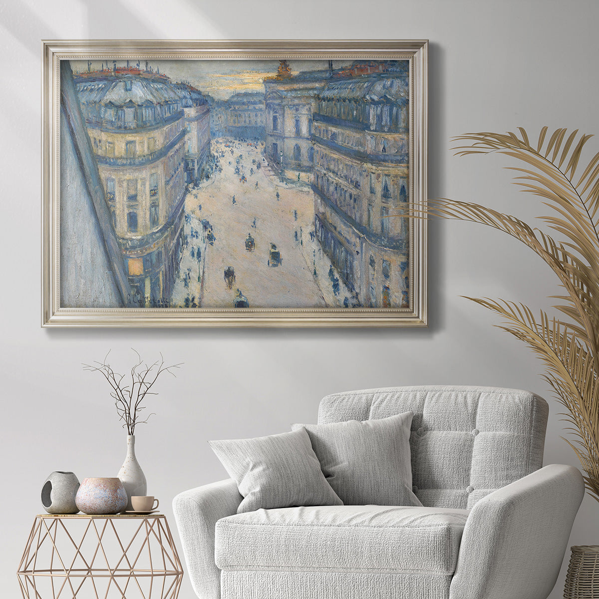Impressionist Paris cityscape viewed from above by Gustave Caillebotte in an ornate champagne frame displayed in a bright interior setting.