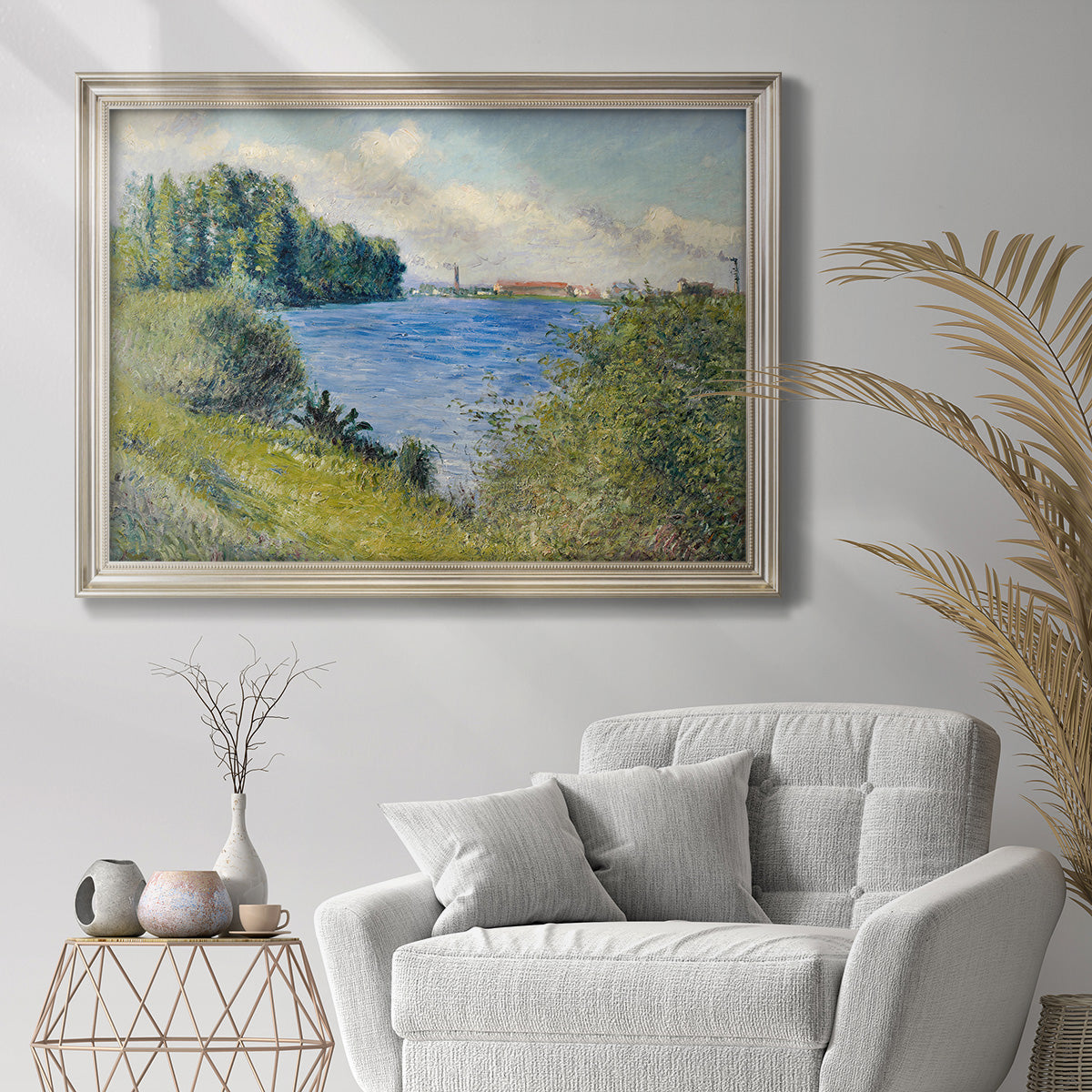 Impressionist river landscape at Argenteuil by Gustave Caillebotte in an ornate champagne frame displayed in a bright interior setting.