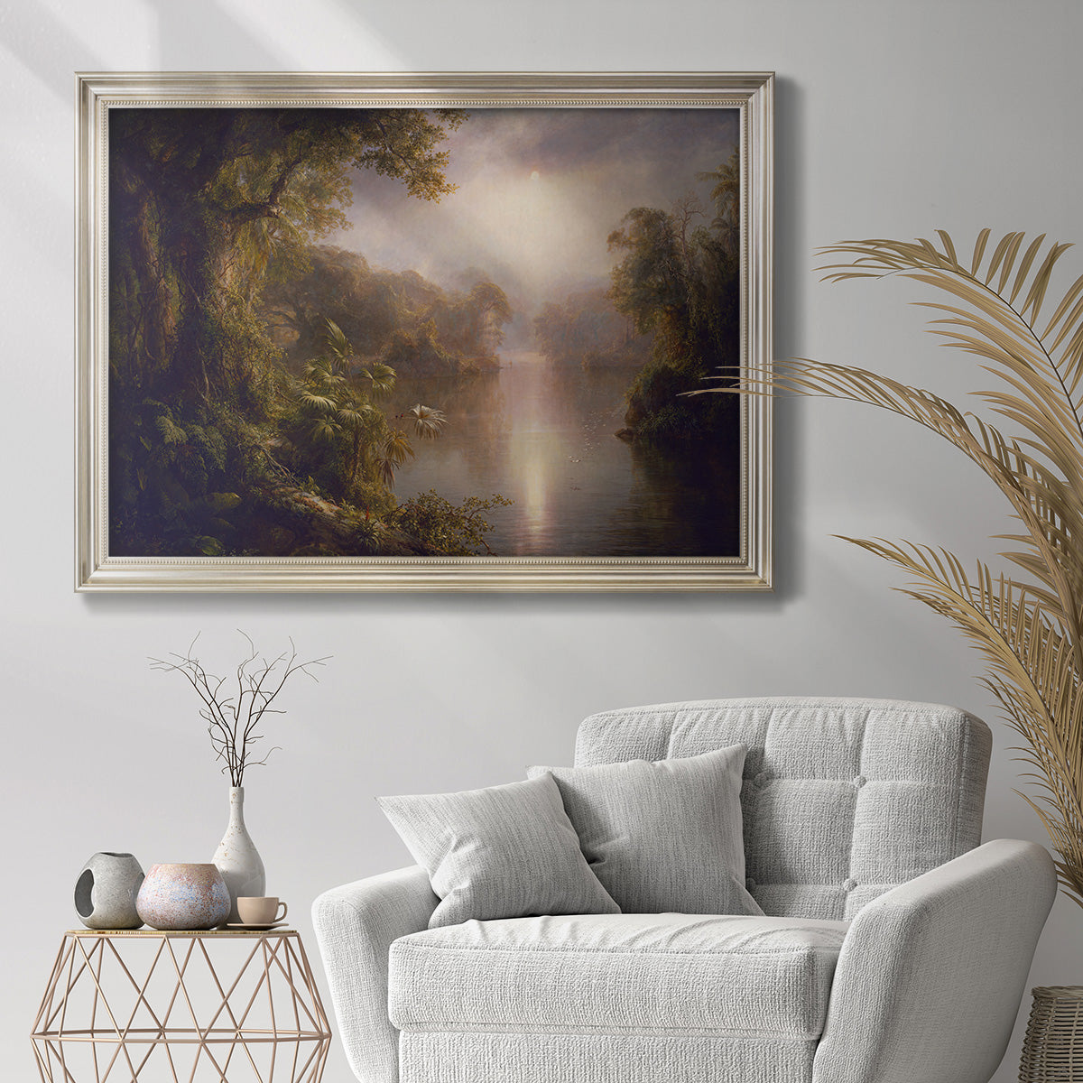 Luminous romantic landscape painting by Frederic Edwin Church in an ornate champagne frame displayed in a bright interior setting.