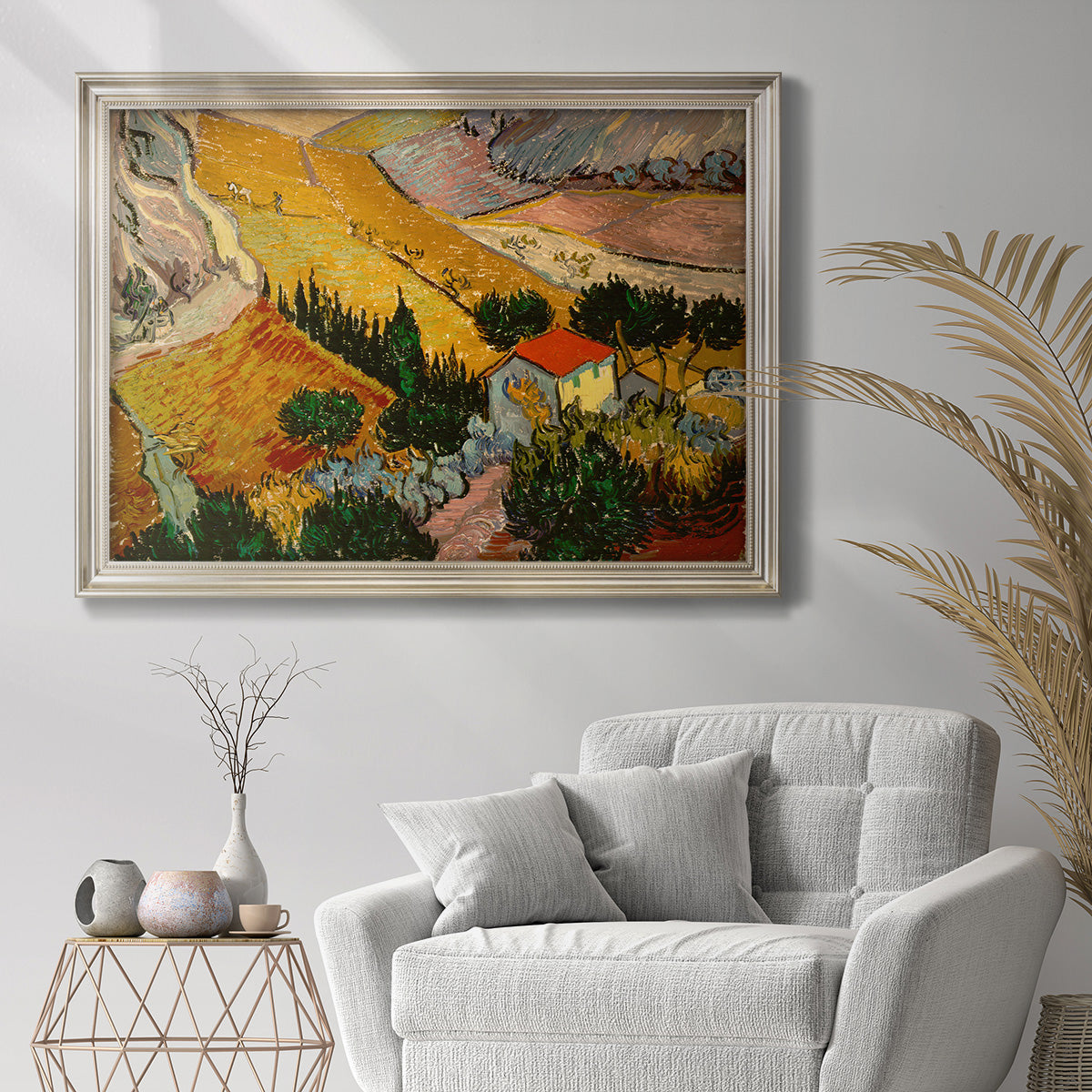 Impressionist rural valley landscape by Vincent van Gogh in an ornate champagne frame displayed in a bright interior setting.