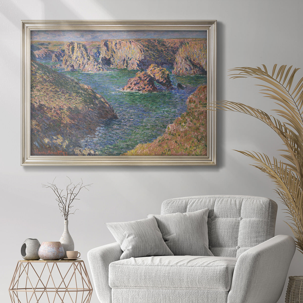 Impressionist rocky coastal seascape at Belle-Île by Claude Monet in an ornate champagne frame displayed in a bright interior setting.
