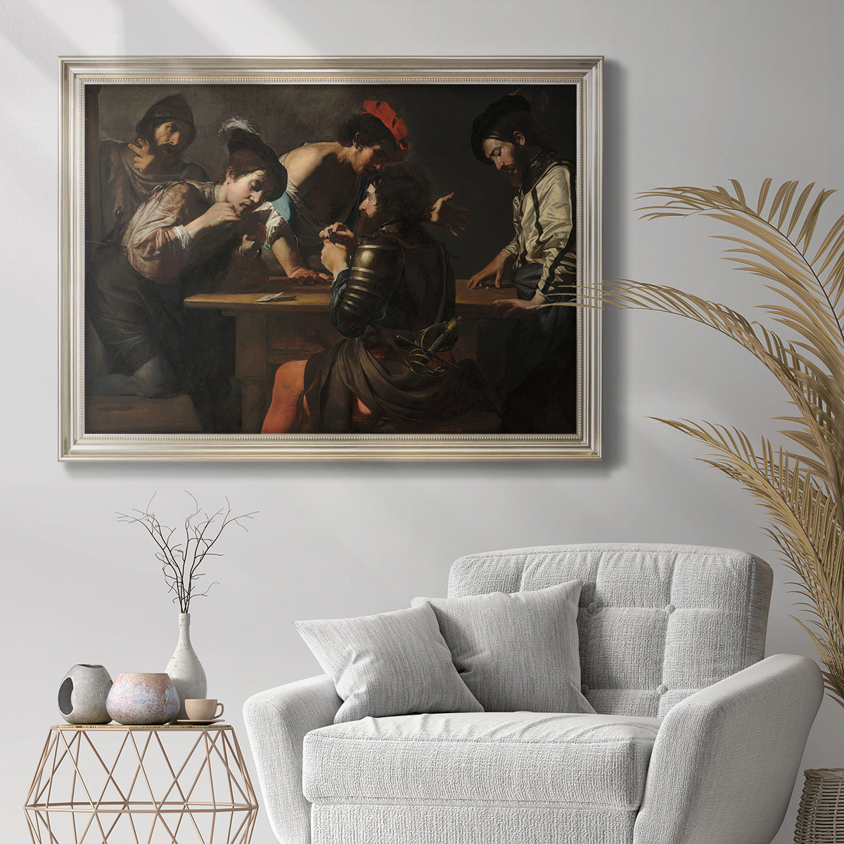 Genre painting of soldiers gambling by Valentin de Boulogne in an ornate champagne frame displayed in a bright interior setting.