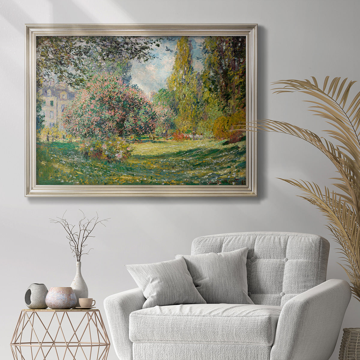Impressionist park landscape in Paris by Claude Monet in an ornate champagne frame displayed in a bright interior setting.
