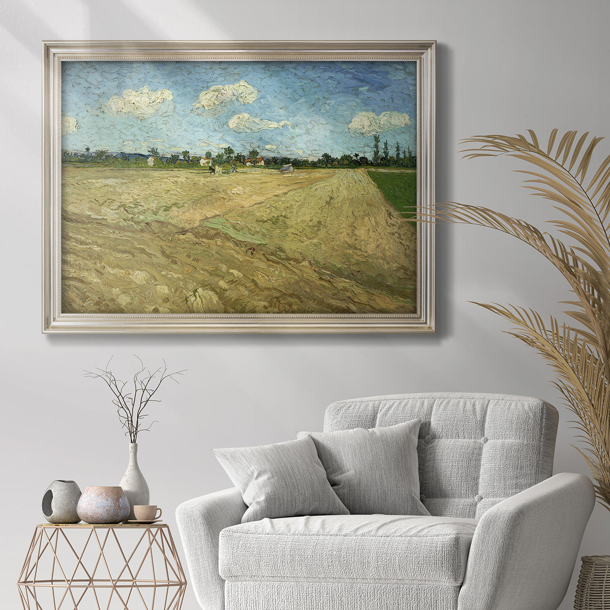 Impressionist ploughed farmland landscape by Vincent van Gogh in an ornate champagne frame displayed in a bright interior setting.