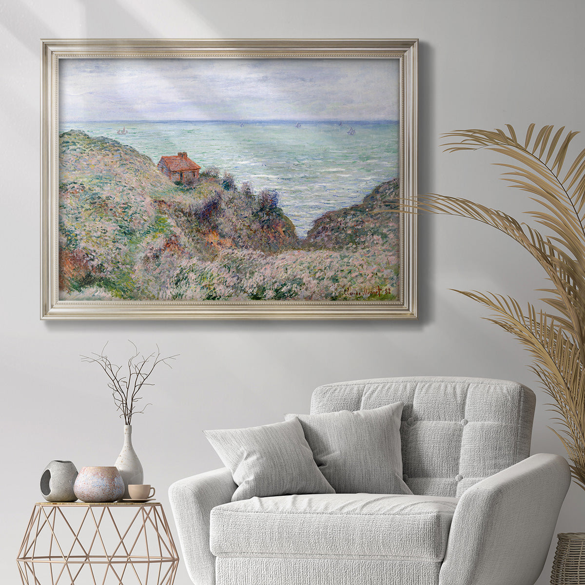 Impressionist coastal watch cabin scene by Claude Monet in an ornate champagne frame displayed in a bright interior setting.