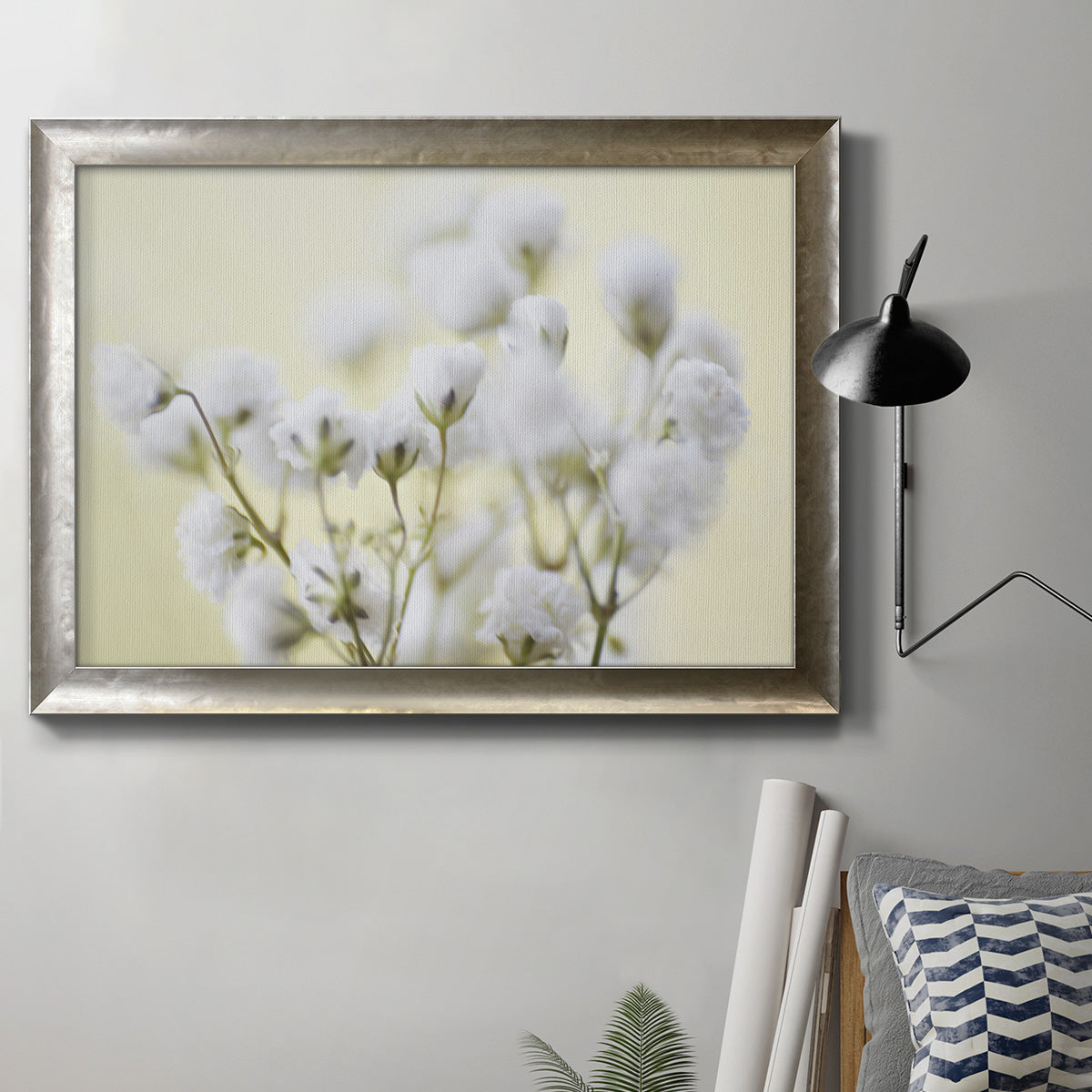 Soft-focus baby’s breath flower photograph in an ornate mottled silver frame displayed in a neutral interior setting.
