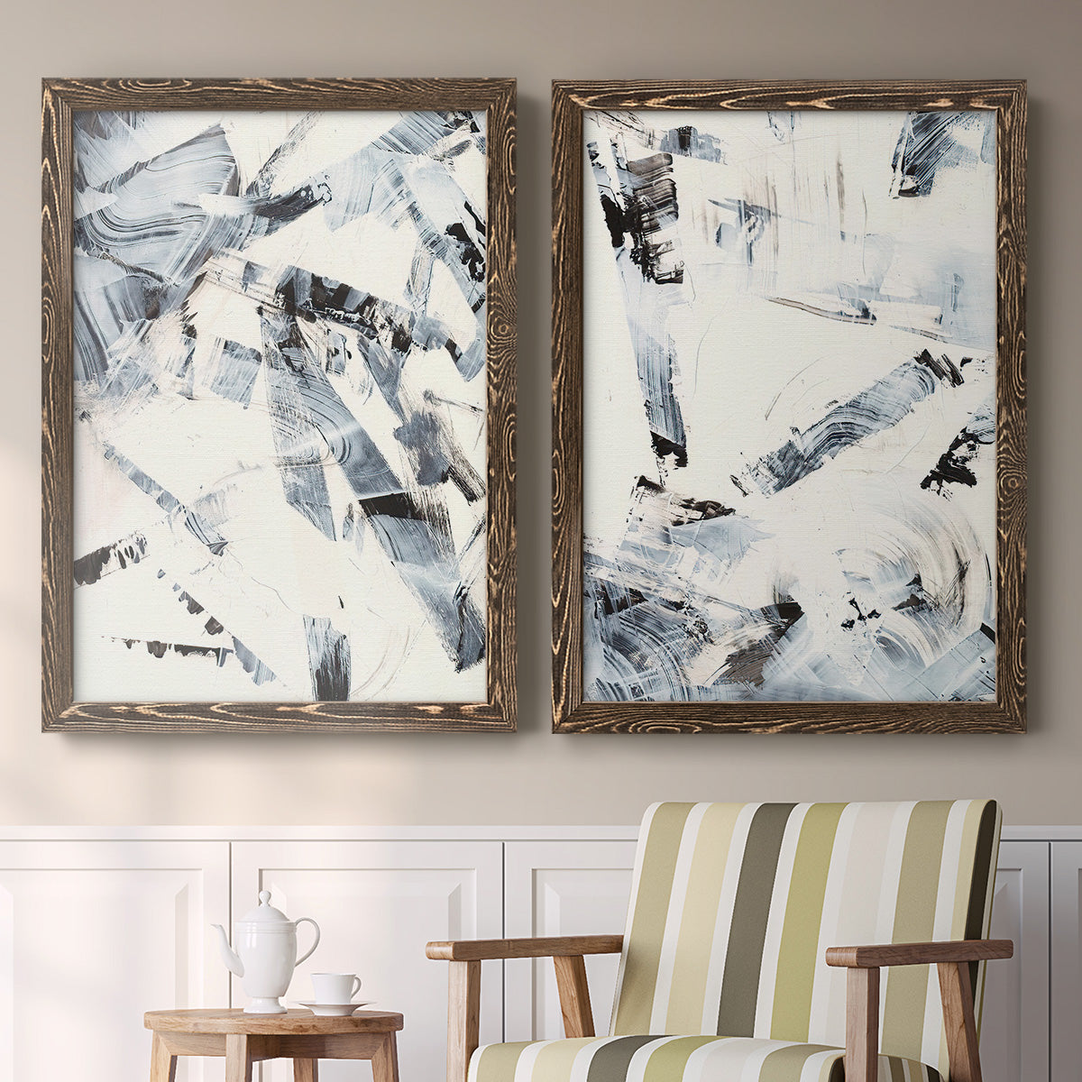 Set of two walnut barnwood framed canvas prints depicting two high-contrast gestural abstracts featuring angular black and gray brush fragments on white above a sideboard in a cozy sitting room.