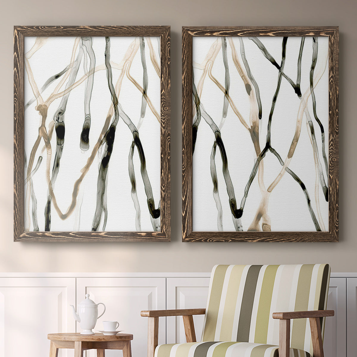 Set of two walnut barnwood framed canvas prints depicting two fluid organic abstracts featuring branching watercolor lines drifting across white above a sideboard in a cozy sitting room.