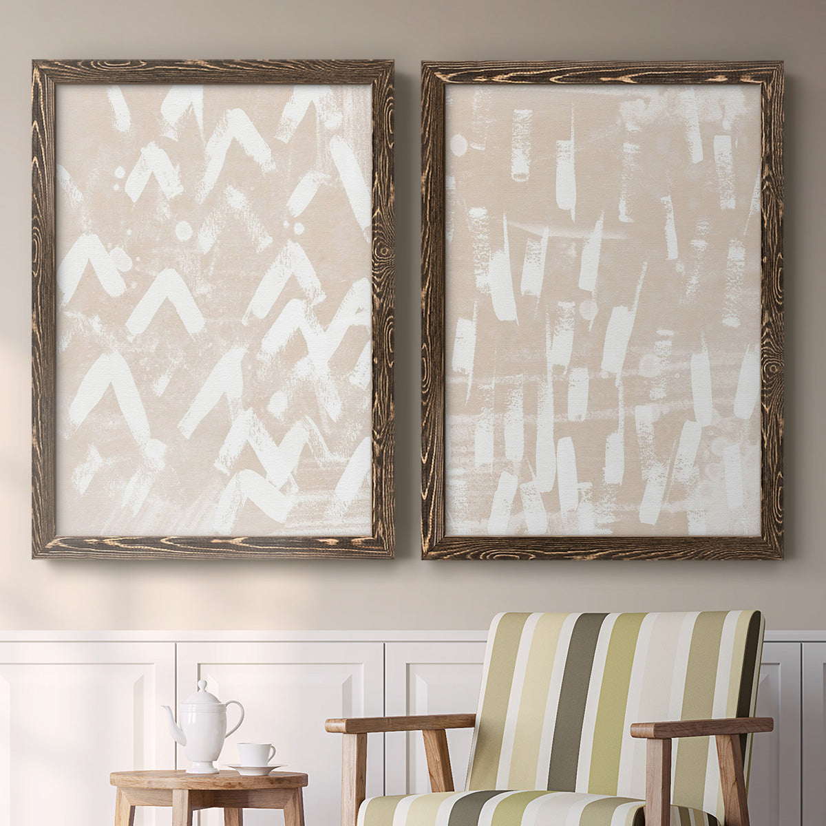 Set of two walnut barnwood framed canvas prints depicting two tribal-inspired pattern abstracts featuring white hand-painted dashes arcs and chevrons above a sideboard in a cozy sitting room.