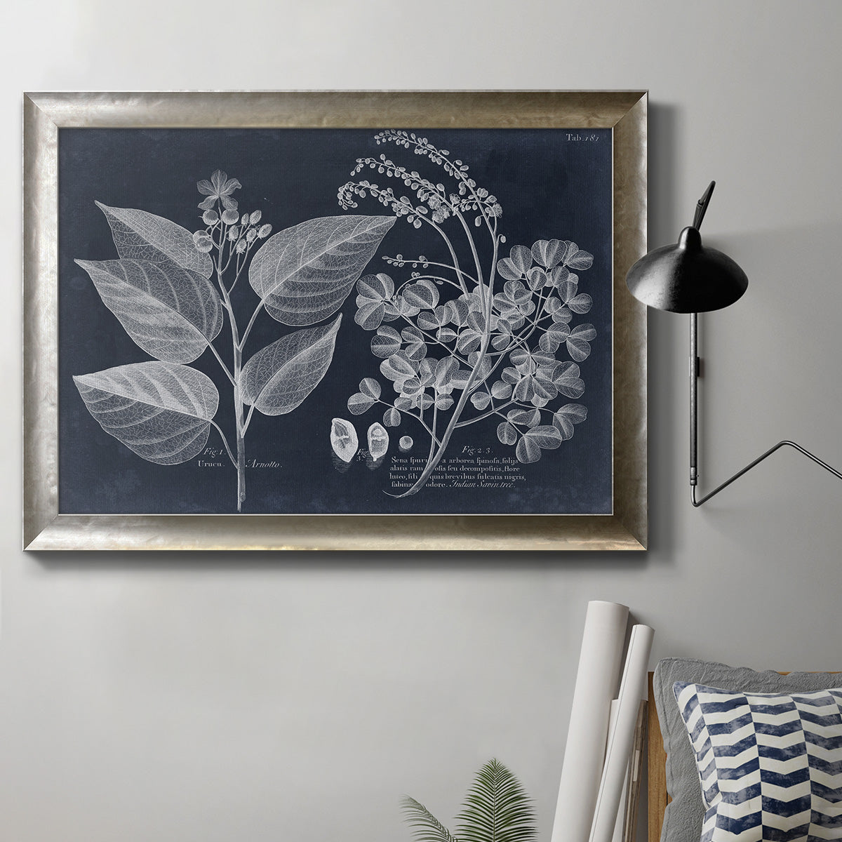 Decorative botanical foliage drawing on navy background in an ornate mottled silver frame displayed in a neutral interior setting.