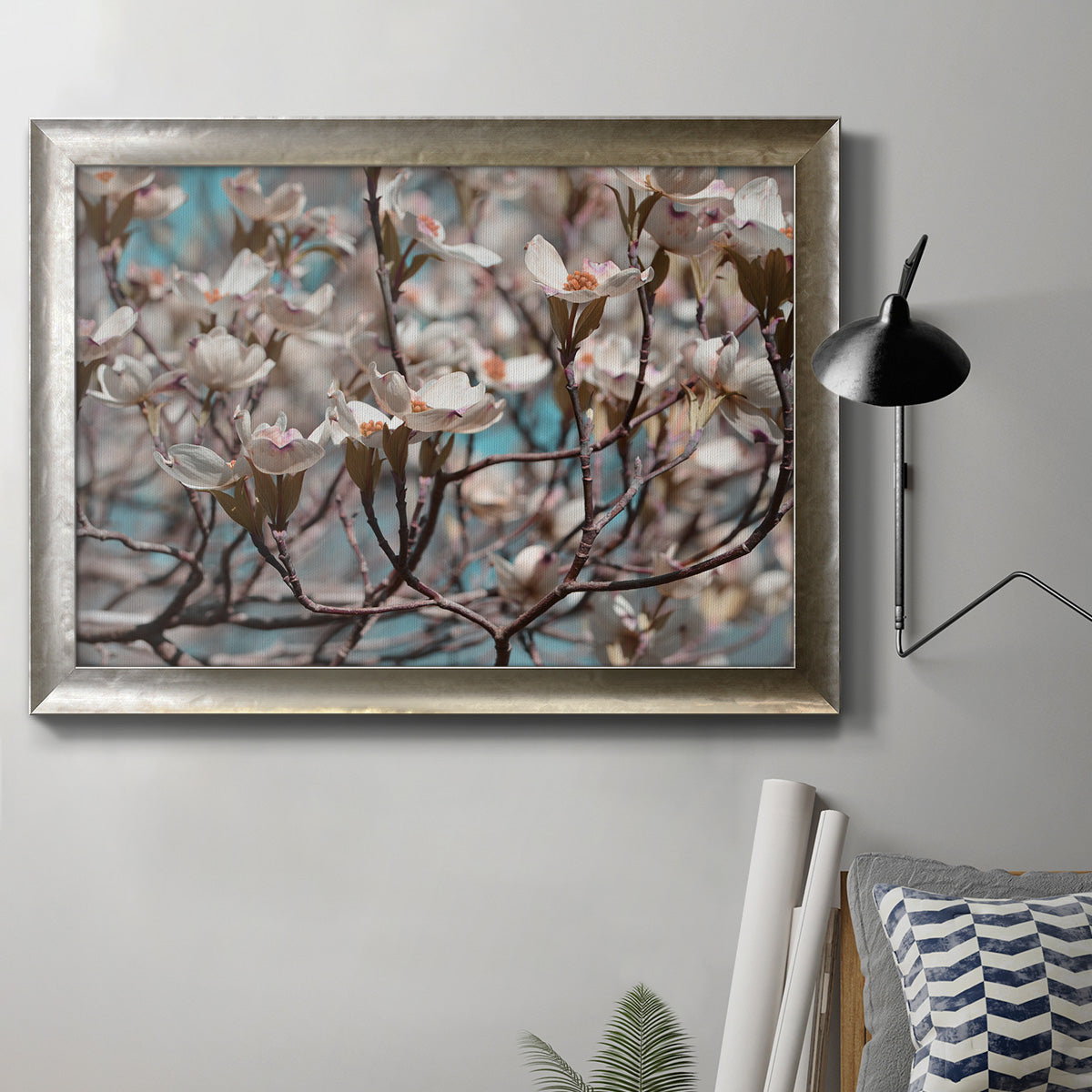 Contemporary dogwood blossom floral photography in an ornate mottled silver frame displayed in a neutral interior setting.