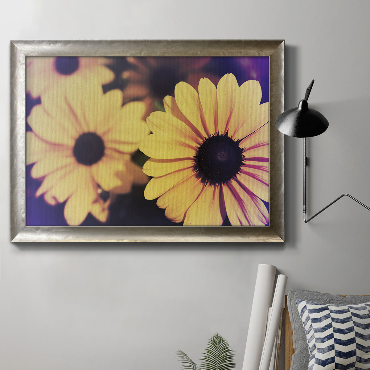 Contemporary yellow Susan floral photograph in an ornate mottled silver frame displayed in a neutral interior setting.