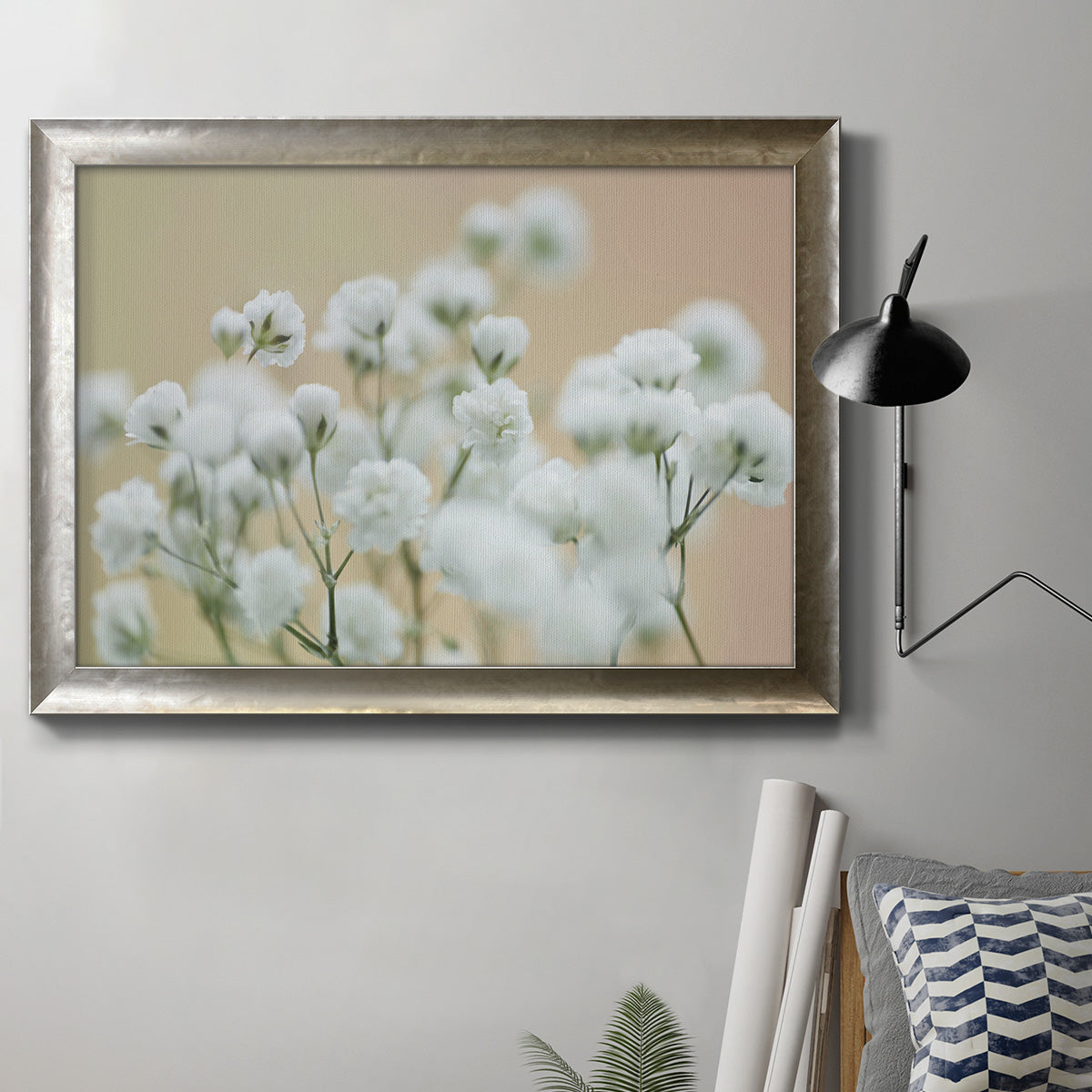 Delicate baby’s breath floral photograph in an ornate mottled silver frame displayed in a neutral interior setting.