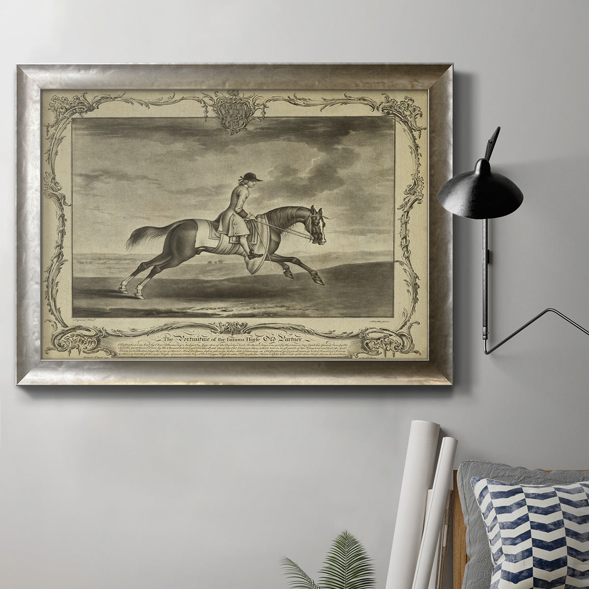 Antique horse illustration in a pastoral landscape in an ornate mottled silver frame displayed in a neutral interior setting.