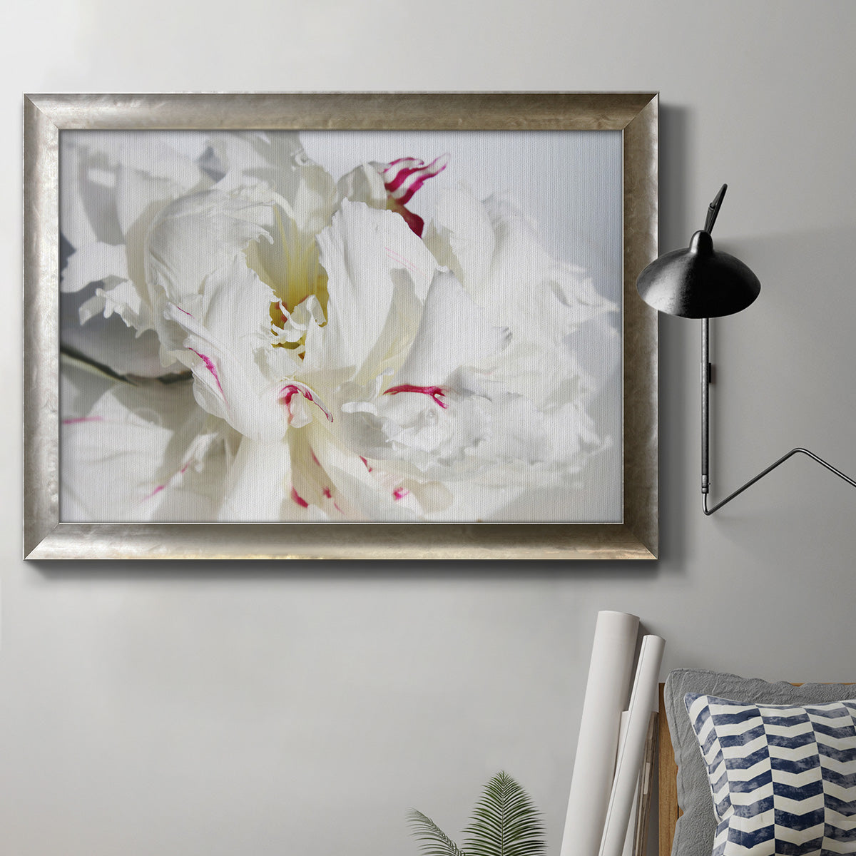 White peony close-up photography in an ornate mottled silver frame displayed in a neutral interior setting.