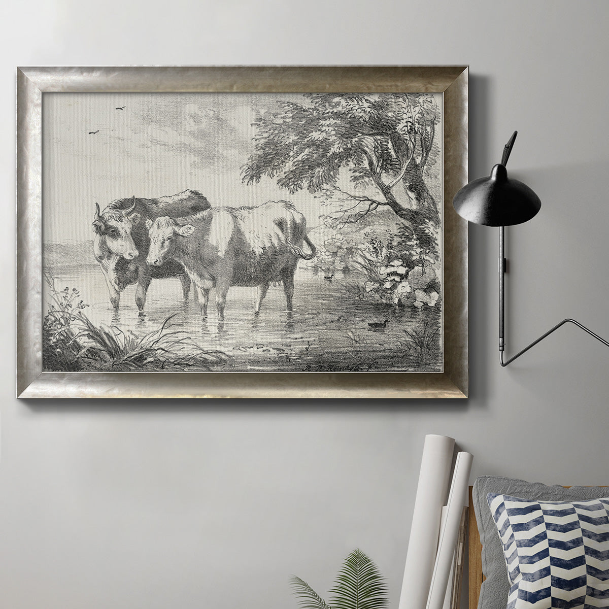 Classical countryside landscape artwork by Nicolas Berchem in an ornate mottled silver frame displayed in a neutral interior setting.