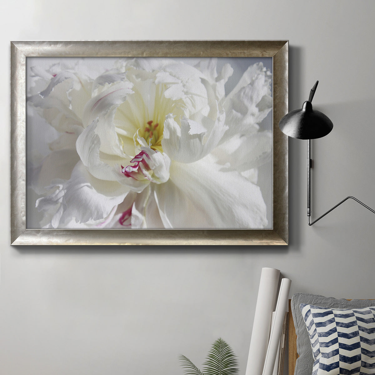 White floral photography close-up in an ornate mottled silver frame displayed in a neutral interior setting.