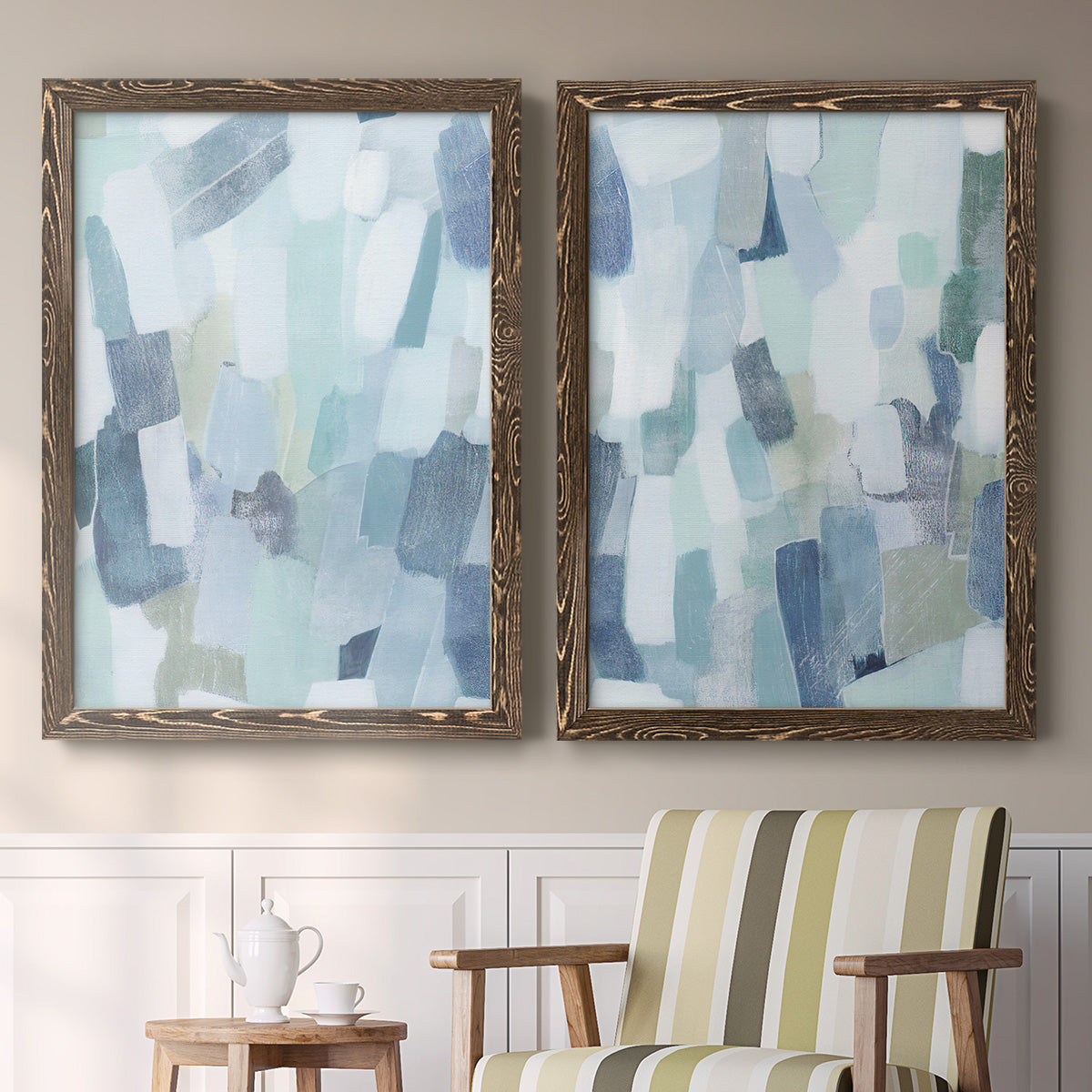 Set of two walnut barnwood framed canvas prints depicting two cool-toned geometric abstracts featuring fragmented pale blue green gray and white brush blocks above a sideboard in a cozy sitting room.