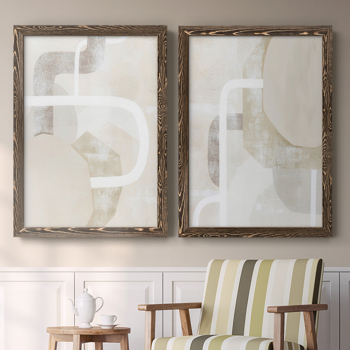 Set of two walnut barnwood framed canvas prints depicting two neutral geometric abstracts with overlapping rounded forms white lines and soft beige gray textures above a sideboard in a cozy sitting room.