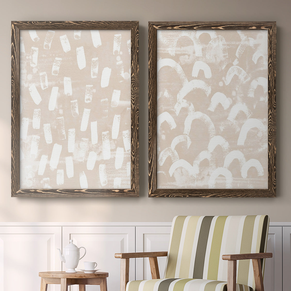 Set of two walnut barnwood framed canvas prints depicting two tribal-inspired pattern abstracts featuring white hand-painted dashes arcs and chevrons above a sideboard in a cozy sitting room.