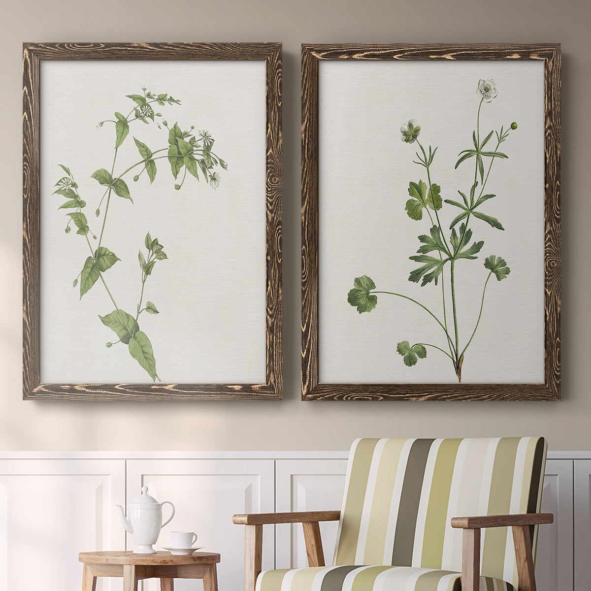 Set of two walnut barnwood framed canvas prints depicting two rustic minimalist botanical studies featuring delicate wildflower and leafy stems above a sideboard in a cozy sitting room.