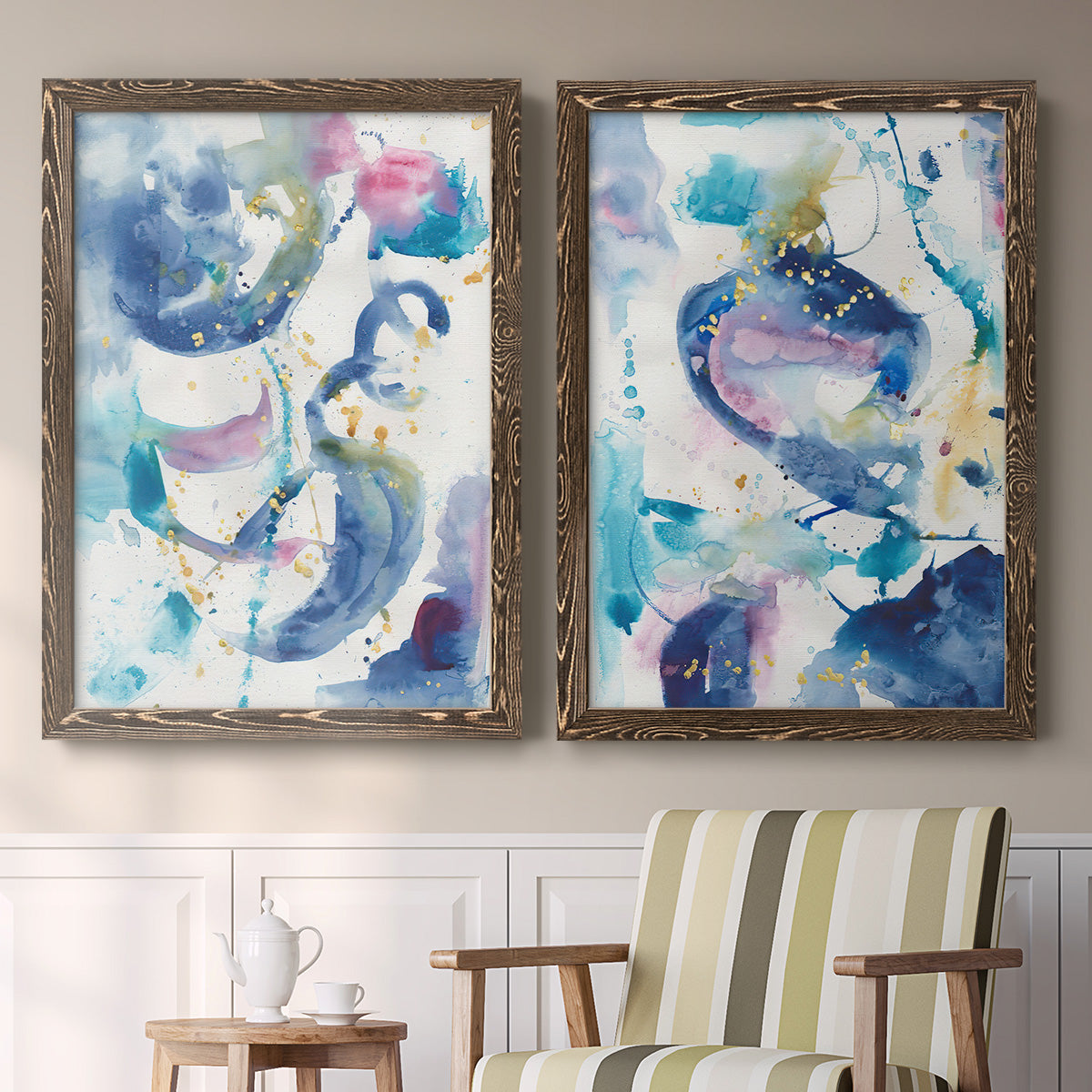 Set of two walnut barnwood framed canvas prints depicting two colorful lyrical abstracts featuring lively blue pink violet and turquoise watercolor gestures above a sideboard in a cozy sitting room.