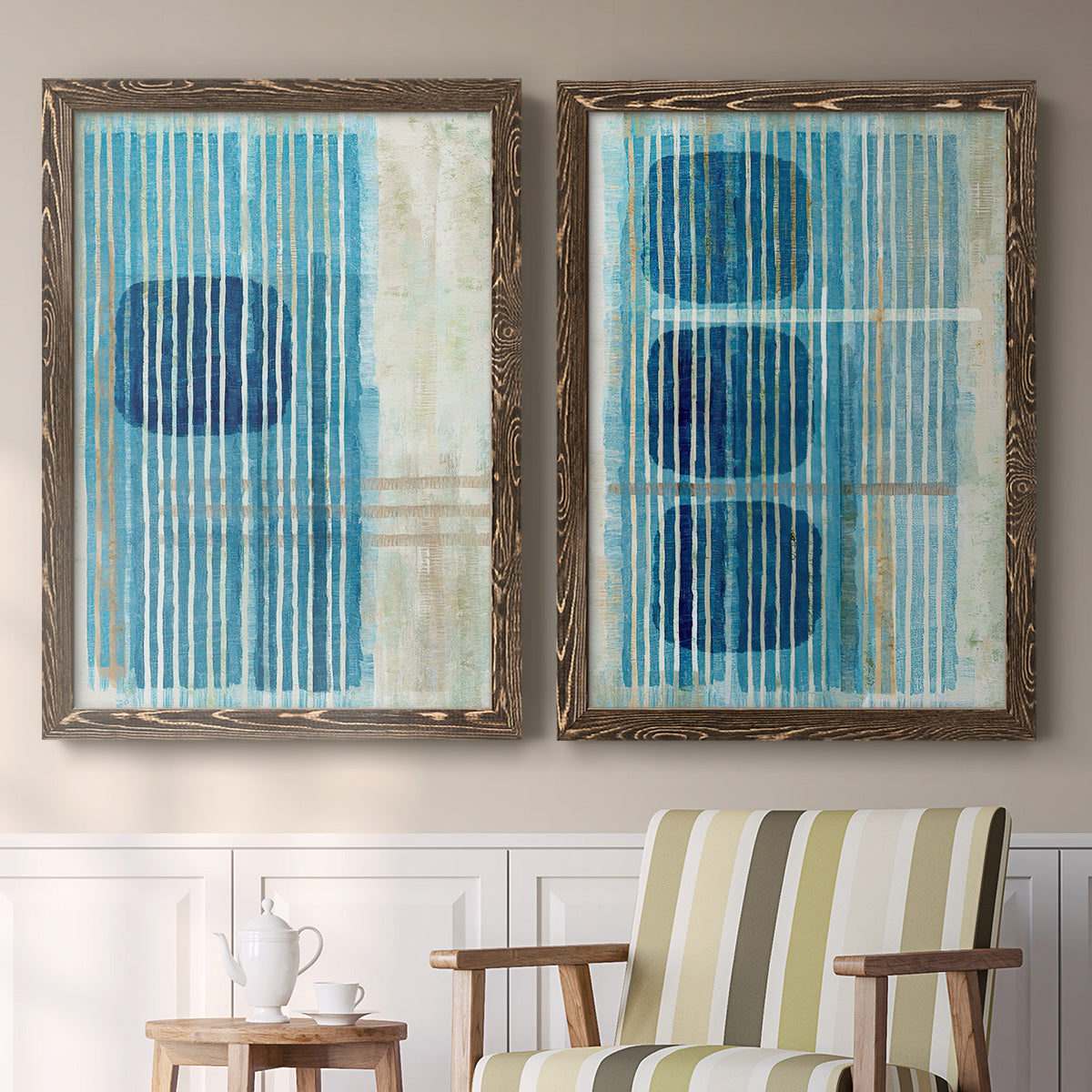 Set of two walnut barnwood framed canvas prints depicting two graphic geometric abstracts featuring stacked blue ovals behind fine vertical stripes above a sideboard in a cozy sitting room.