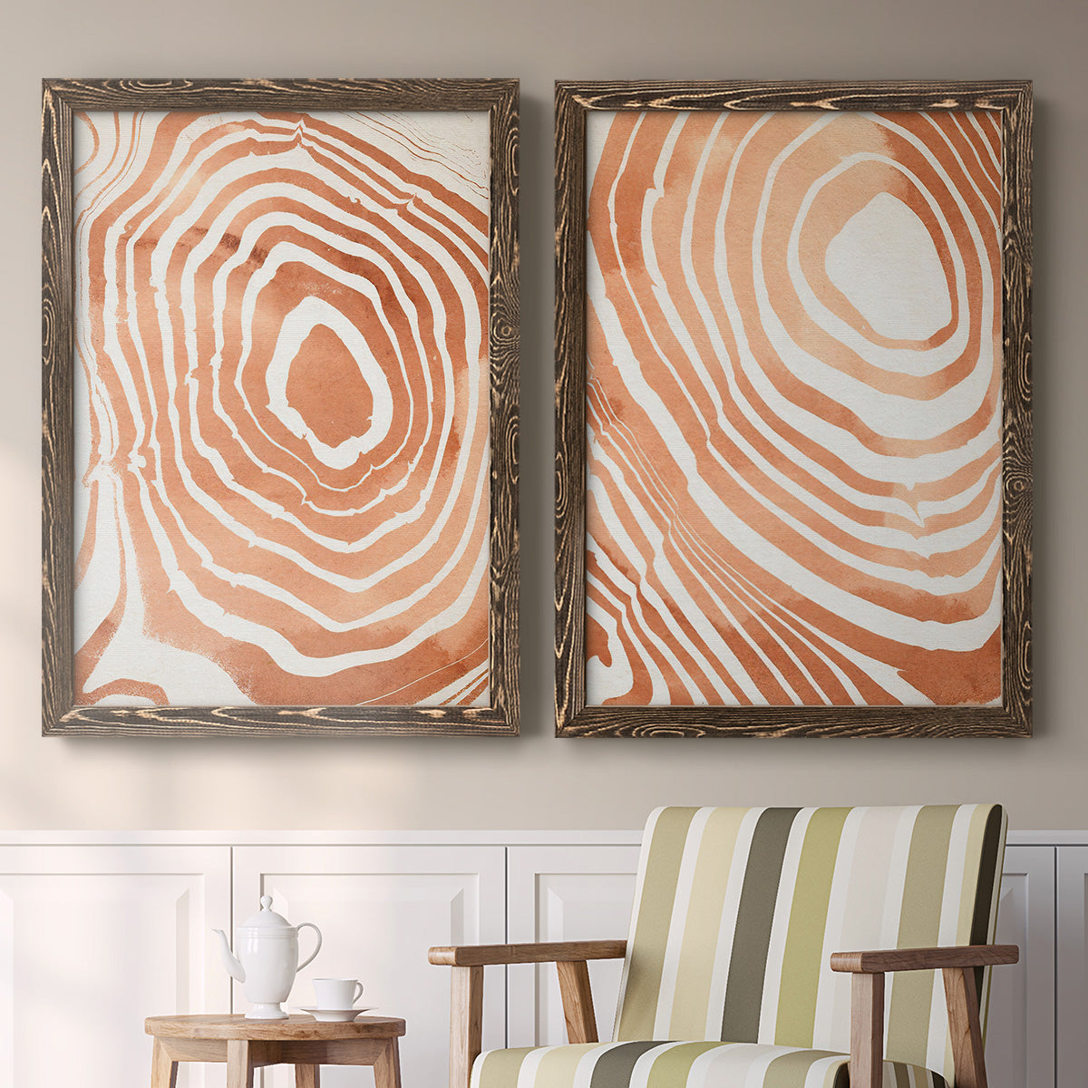 Set of two walnut barnwood framed canvas prints depicting two minimalist marbled pattern abstracts featuring concentric wood-grain rings and rippling contour lines above a sideboard in a cozy sitting room.