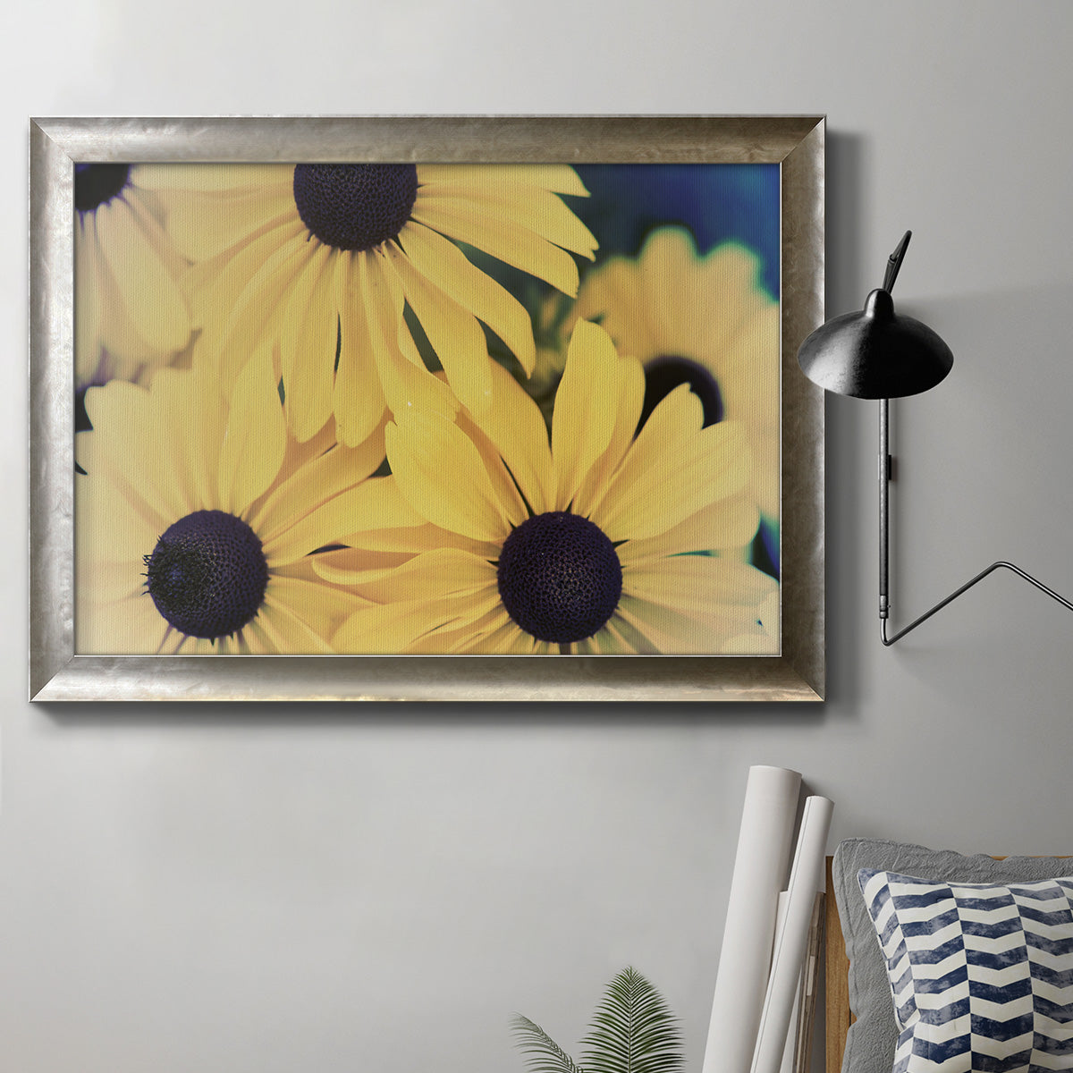 Modern sunflower-style Susan floral photograph in an ornate mottled silver frame displayed in a neutral interior setting.