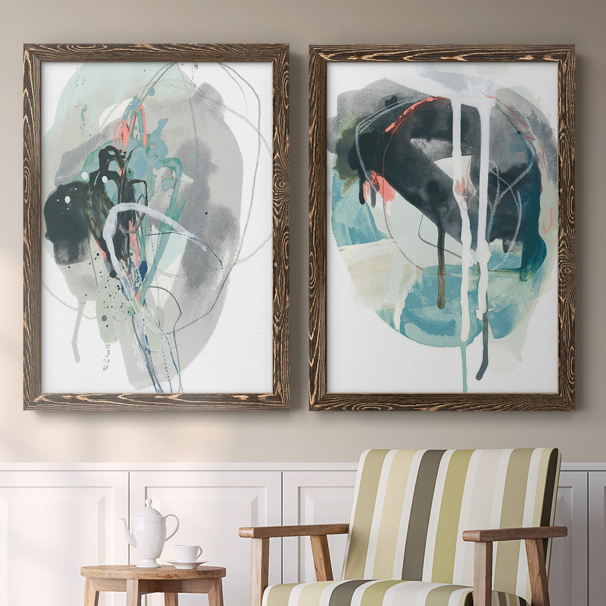Set of two walnut barnwood framed canvas prints depicting two bold gestural abstracts featuring large black gray and teal circular gestures above a sideboard in a cozy sitting room.