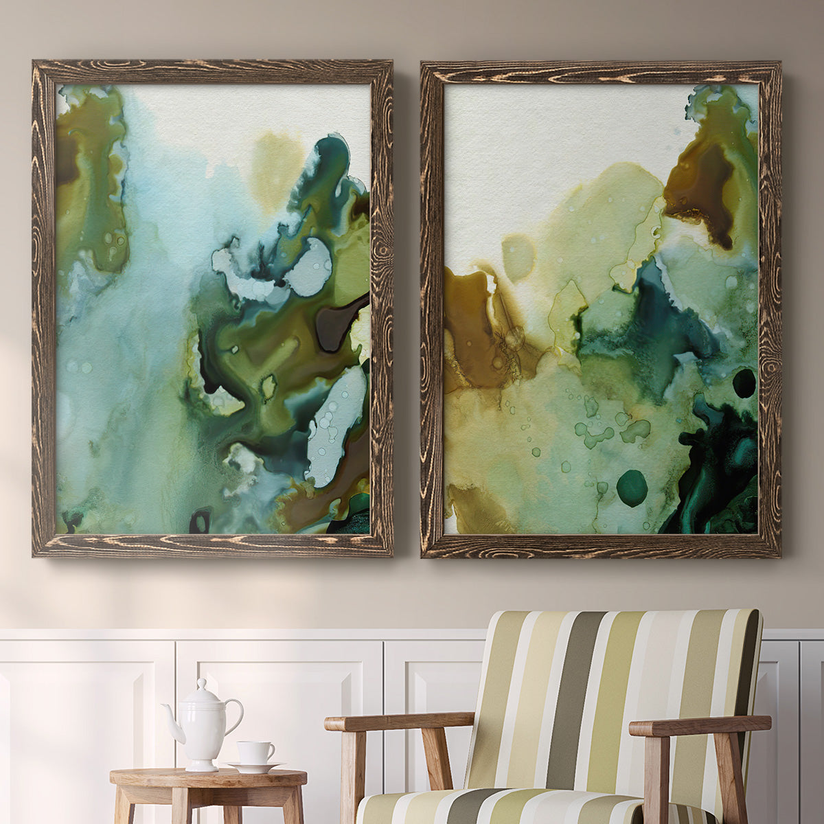 Set of two walnut barnwood framed canvas prints depicting two organic watercolor abstracts featuring fluid green blue and earthy brown ink pools above a sideboard in a cozy sitting room.