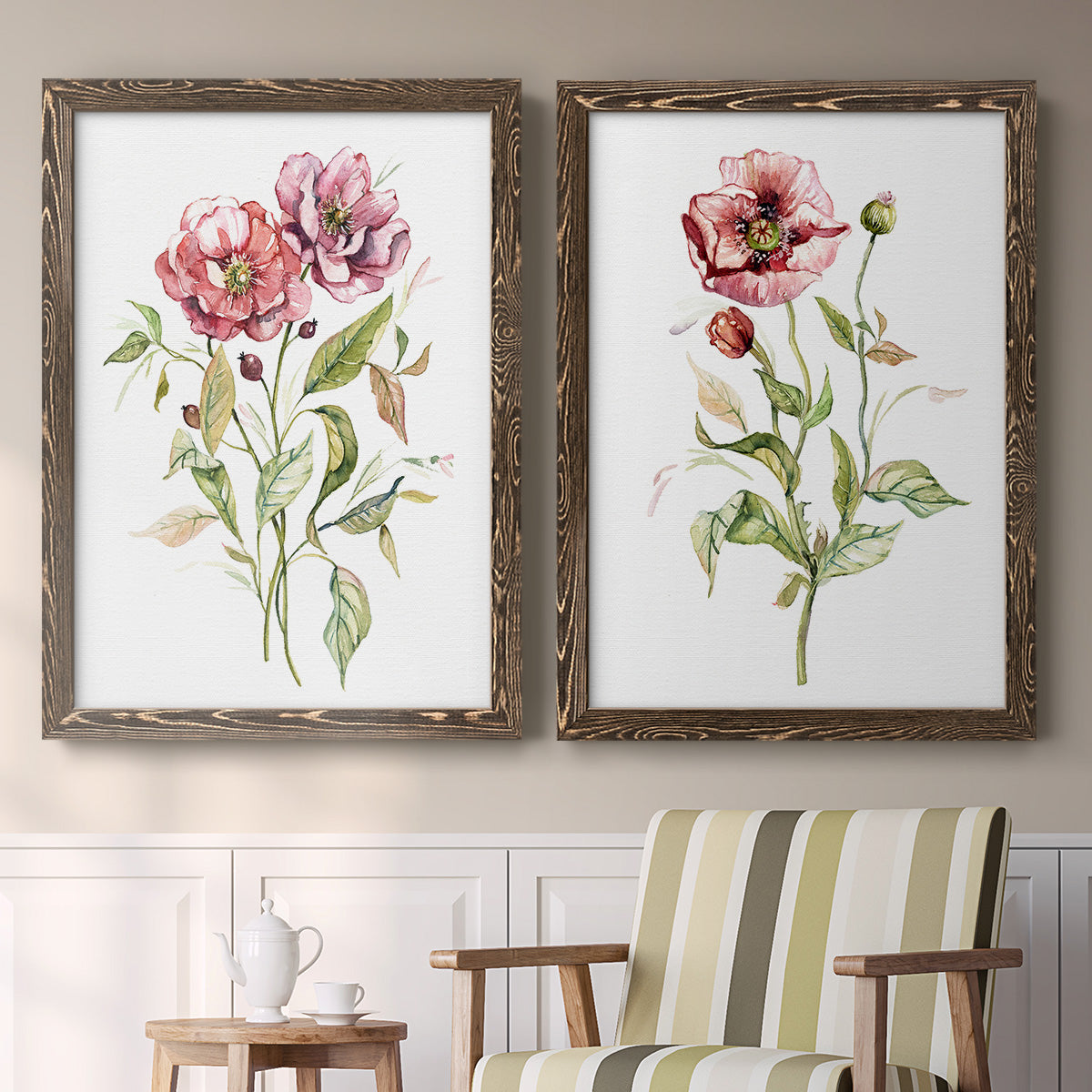 Set of two walnut barnwood framed canvas prints depicting two traditional watercolor flower studies featuring two airy wildflower stems with pink and burgundy blossoms above a sideboard in a cozy sitting room.
