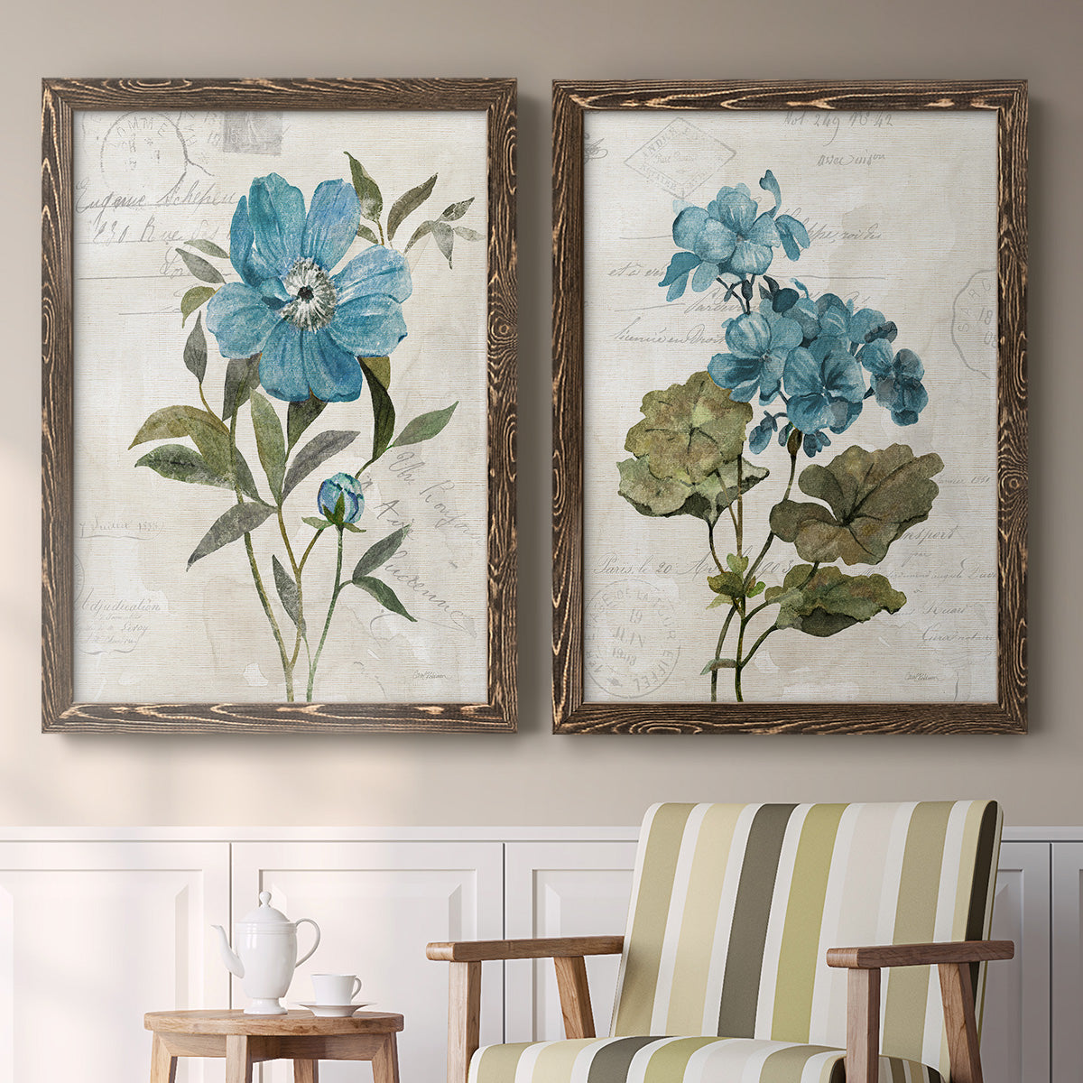 Set of two walnut barnwood framed canvas prints depicting two rustic floral illustrations featuring blue peony and hydrangea-like blooms over vintage script above a sideboard in a cozy sitting room.
