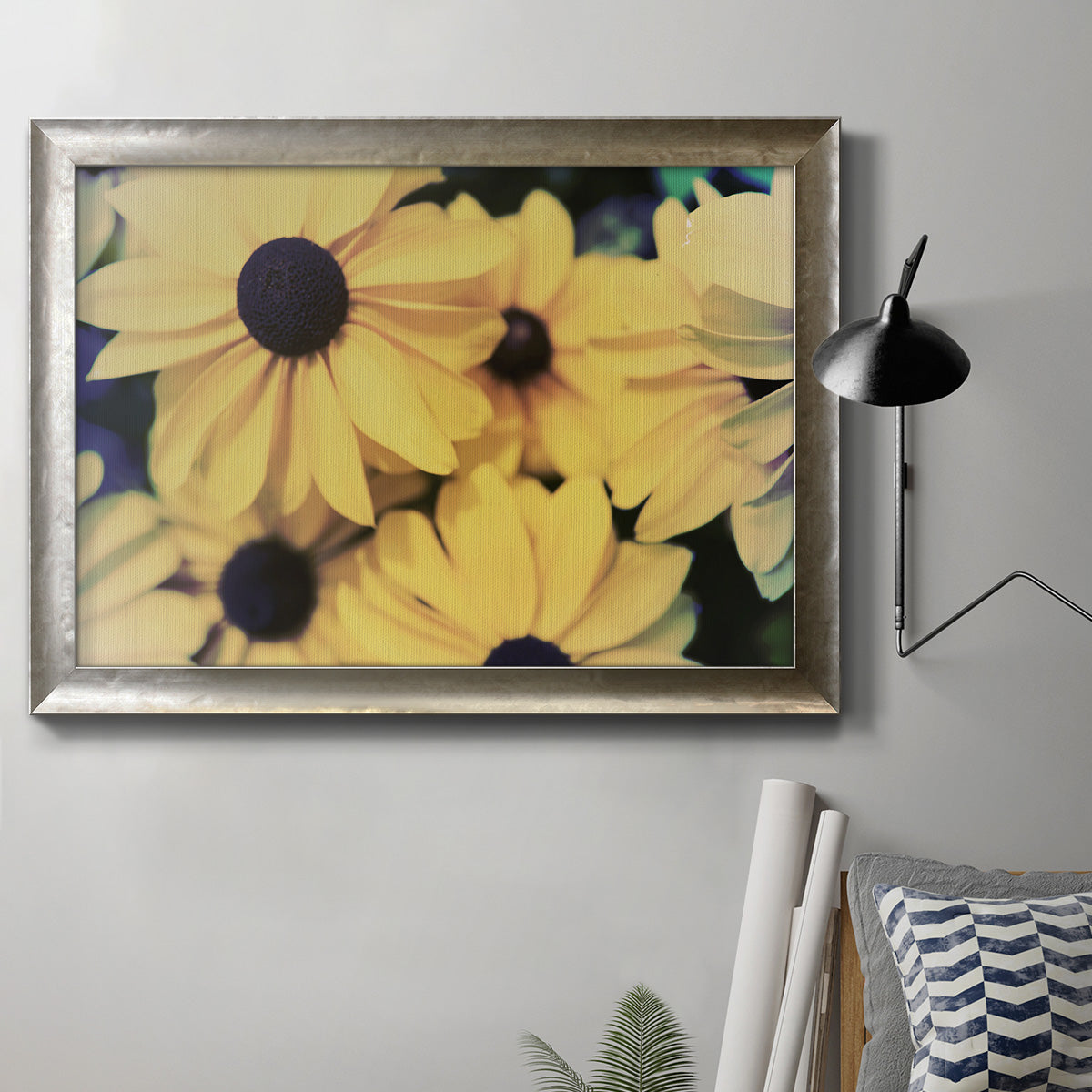 Contemporary black-eyed Susan floral photography in an ornate mottled silver frame displayed in a neutral interior setting.