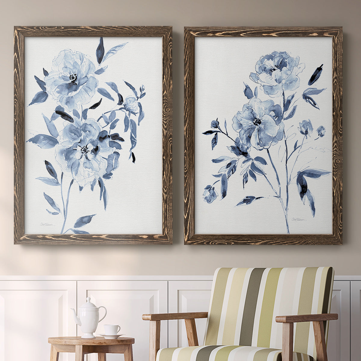 Set of two walnut barnwood framed canvas prints depicting two expressive watercolor botanical paintings featuring loose blue flowers and leafy branches above a sideboard in a cozy sitting room.