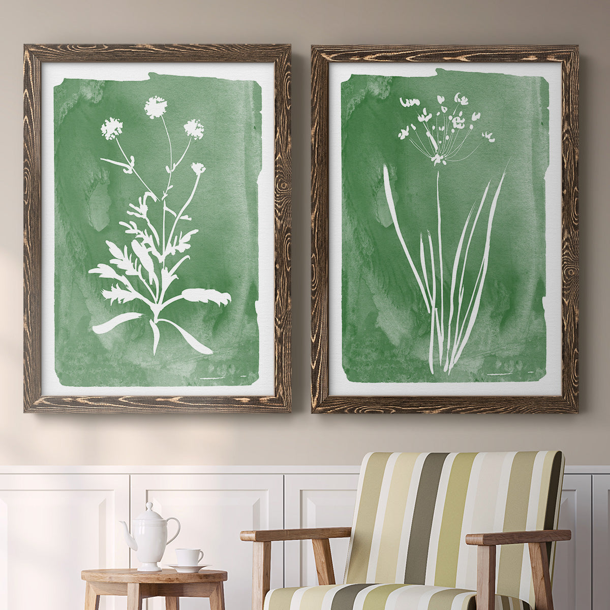 Set of two walnut barnwood framed canvas prints depicting two rustic minimalist botanical studies featuring delicate wildflower and leafy stems above a sideboard in a cozy sitting room.