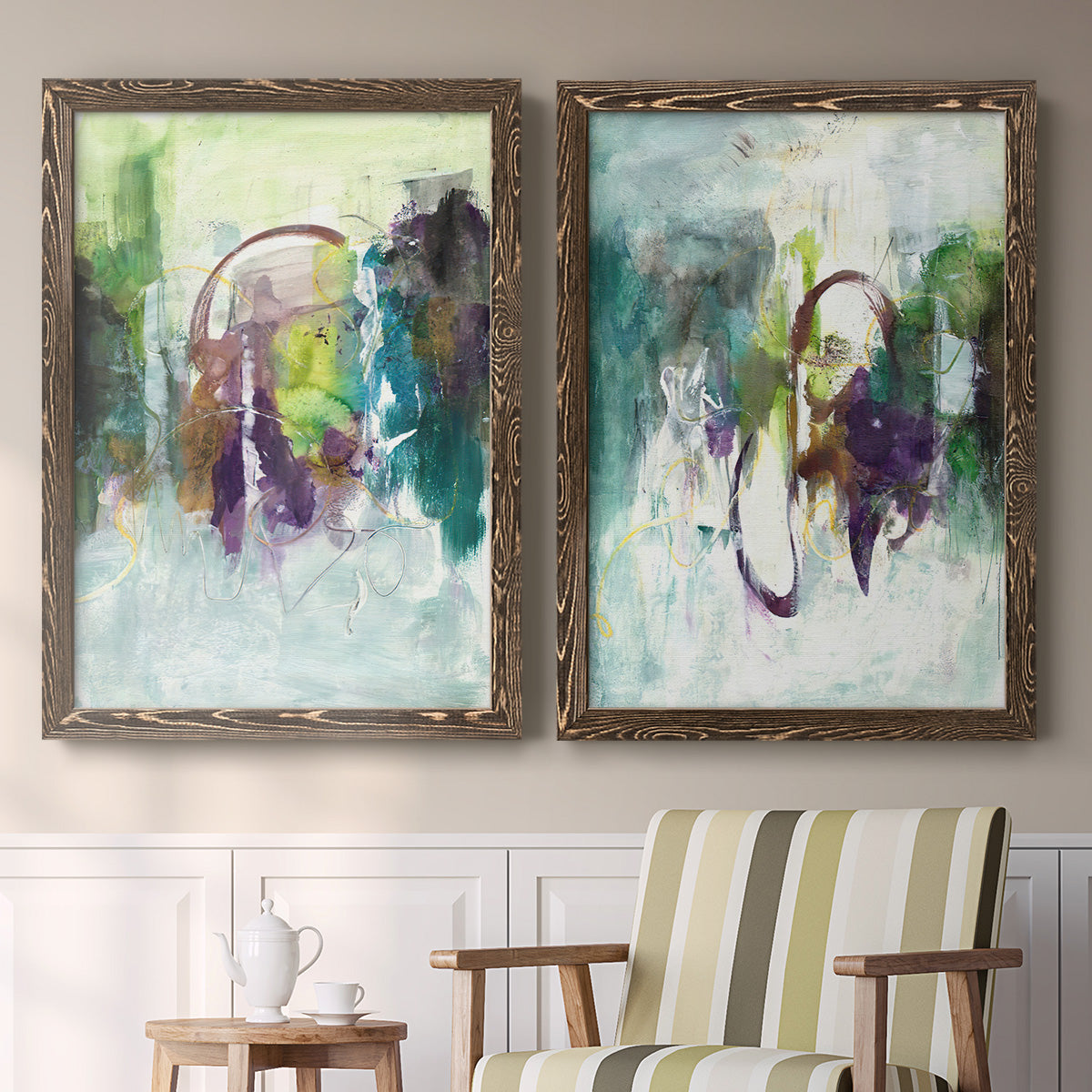 Set of two walnut barnwood framed canvas prints depicting two expressive contemporary abstracts featuring layered green purple and gray painterly forms above a sideboard in a cozy sitting room.