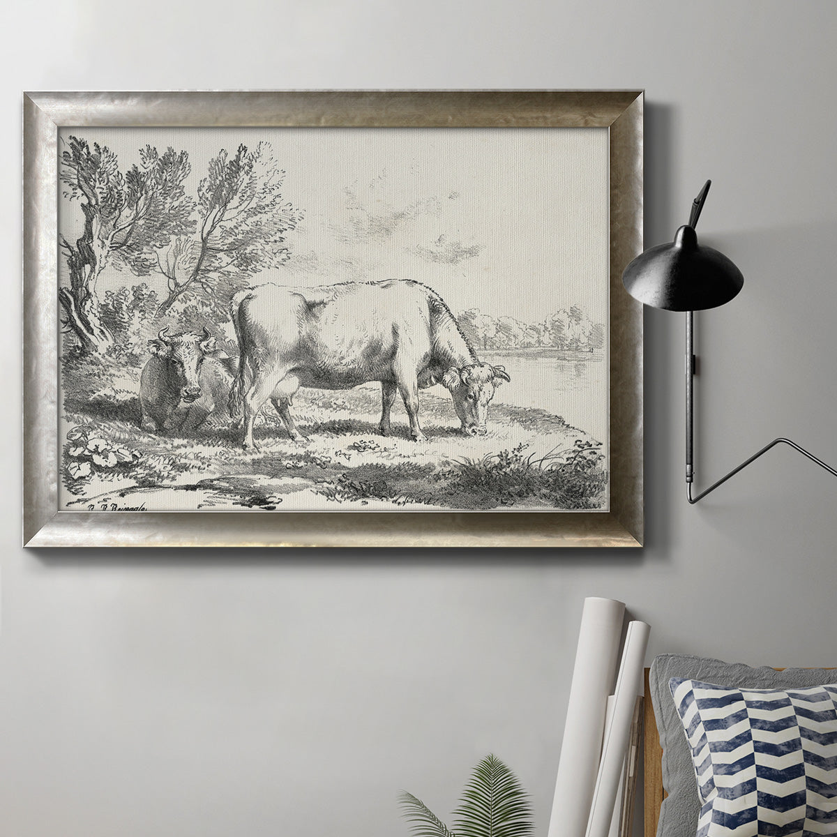 Traditional rural landscape scene by Nicolas Berchem in an ornate mottled silver frame displayed in a neutral interior setting.