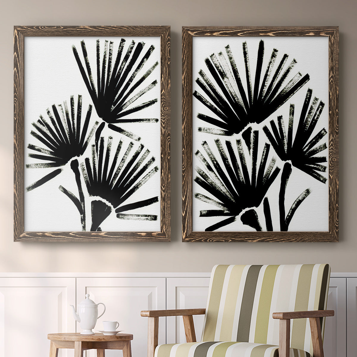 Set of two walnut barnwood framed canvas prints depicting two bold monochrome botanical prints featuring black fan-shaped botanical forms above a sideboard in a cozy sitting room.